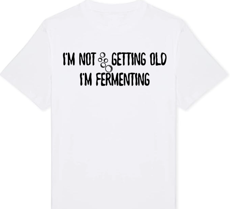 A white t-shirt with the phrase "I’m Not Getting Old, I’m Fermenting" and a cluster of cartoon-style bubbles between the words "not" and "getting."